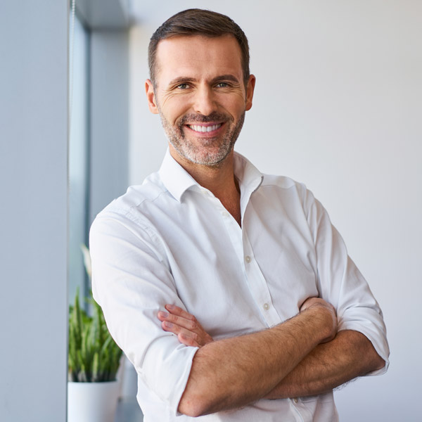 man smiling with arms crossed in front of him